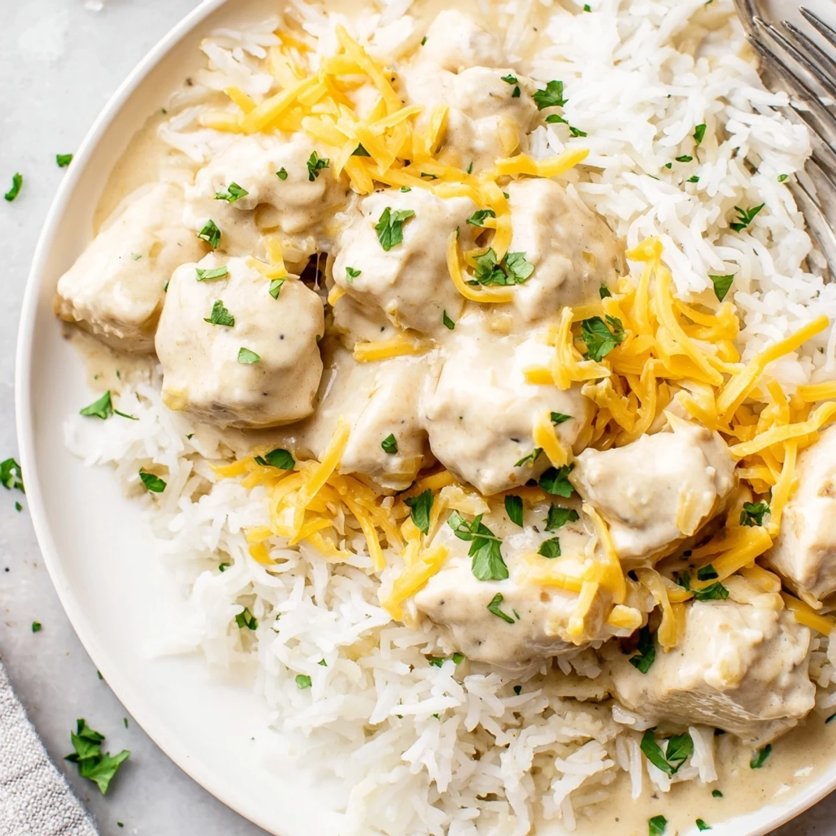 Comforting chicken and rice dish featuring tender meat smothered in savory cream sauce and melted cheese