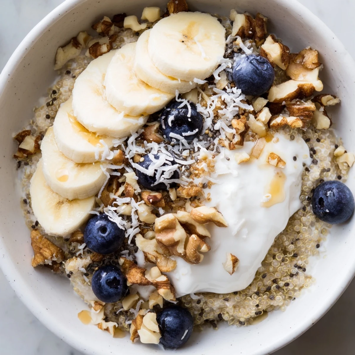 Vibrant blueberry quinoa breakfast bowl featuring Greek yogurt, fresh berries, and walnuts in a rustic ceramic bowl