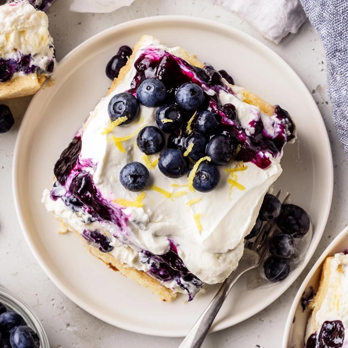 No-bake lemon blueberry lasagna layered in a glass dish topped with fresh berries