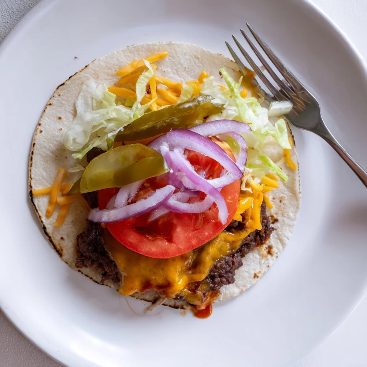 Smash Burger Tacos sizzling in a cast iron skillet, melty cheddar topping