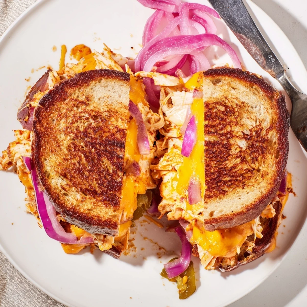 Golden BBQ chicken grilled cheese sandwich with melted cheddar on sourdough bread