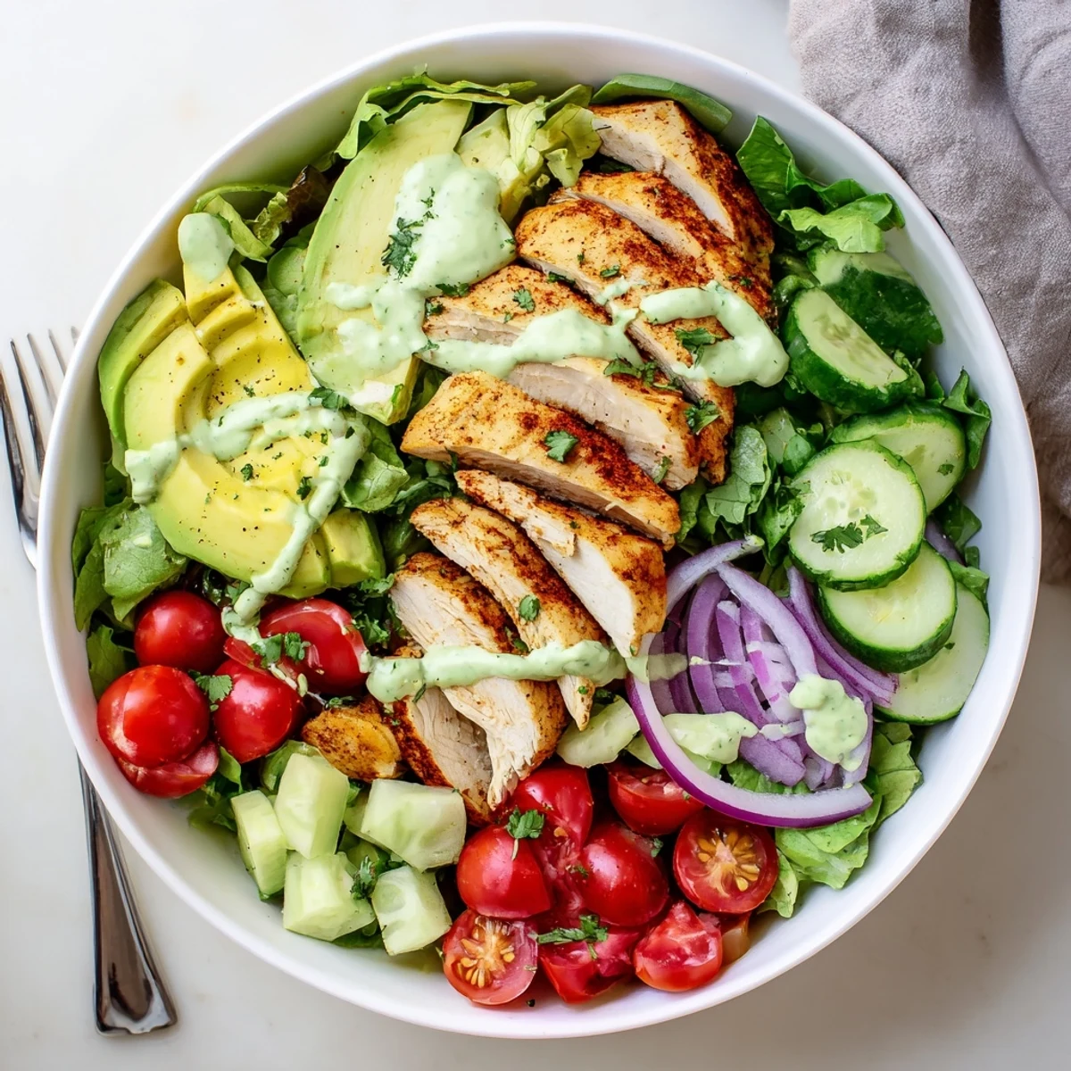 Nutritious salad bowl packed with tender grilled chicken, ripe avocado, mixed vegetables, and smooth creamy dressing.