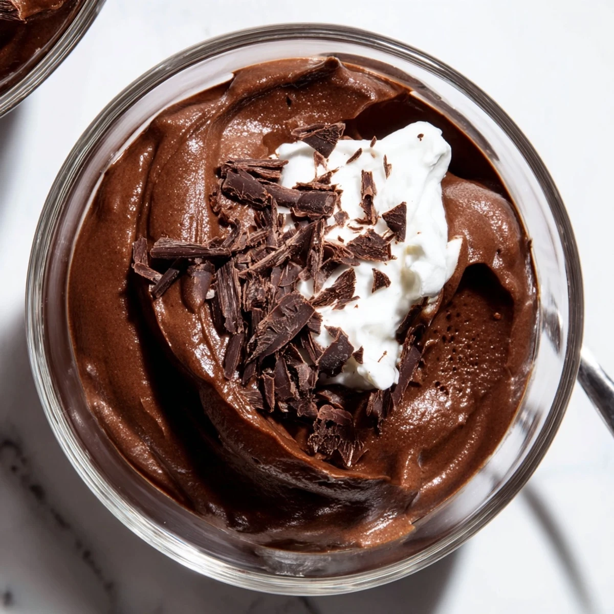 Velvety chocolate mousse served in elegant glasses topped with delicate whipped cream