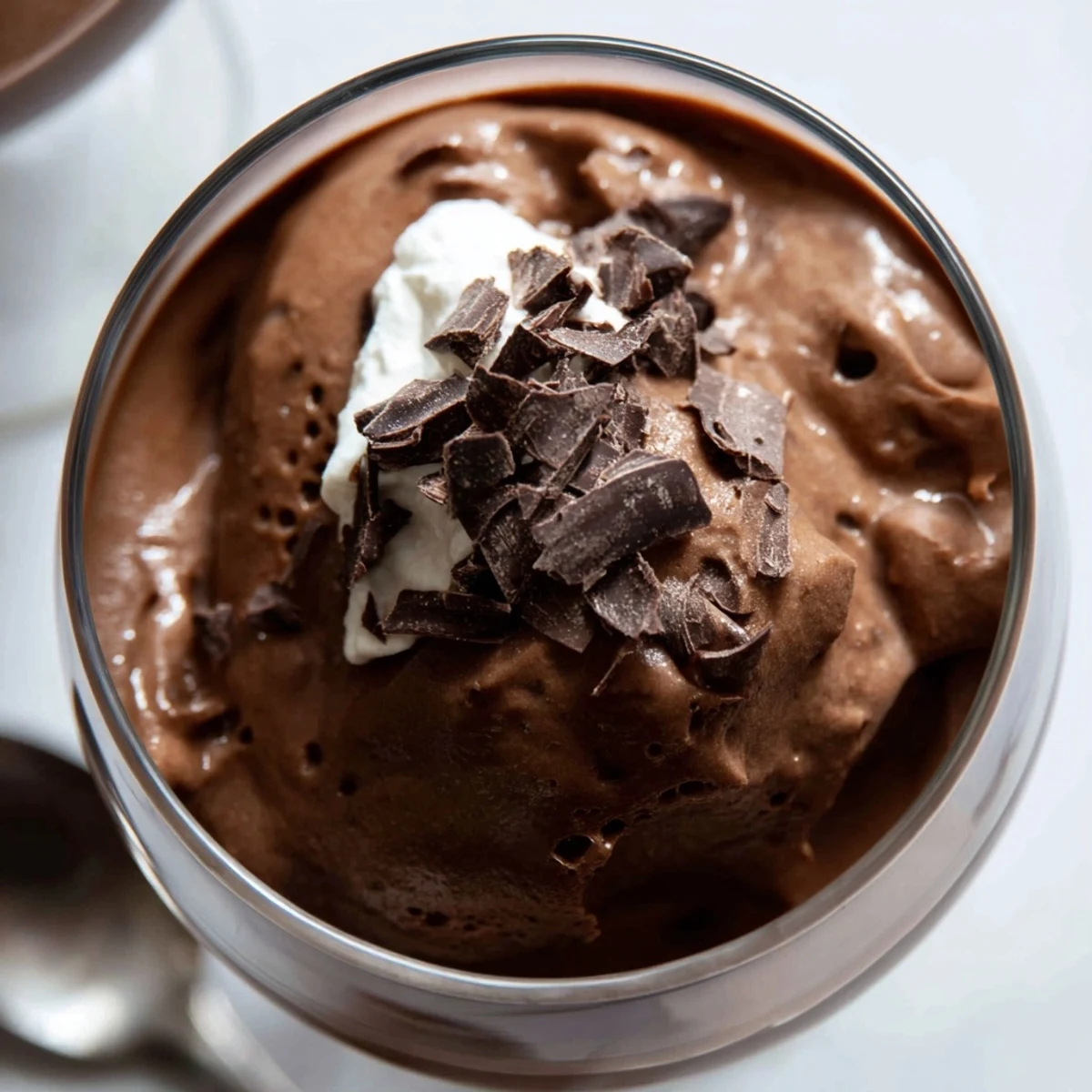 Silky chocolate mousse spooned into ramekins with dark cocoa shavings and mint