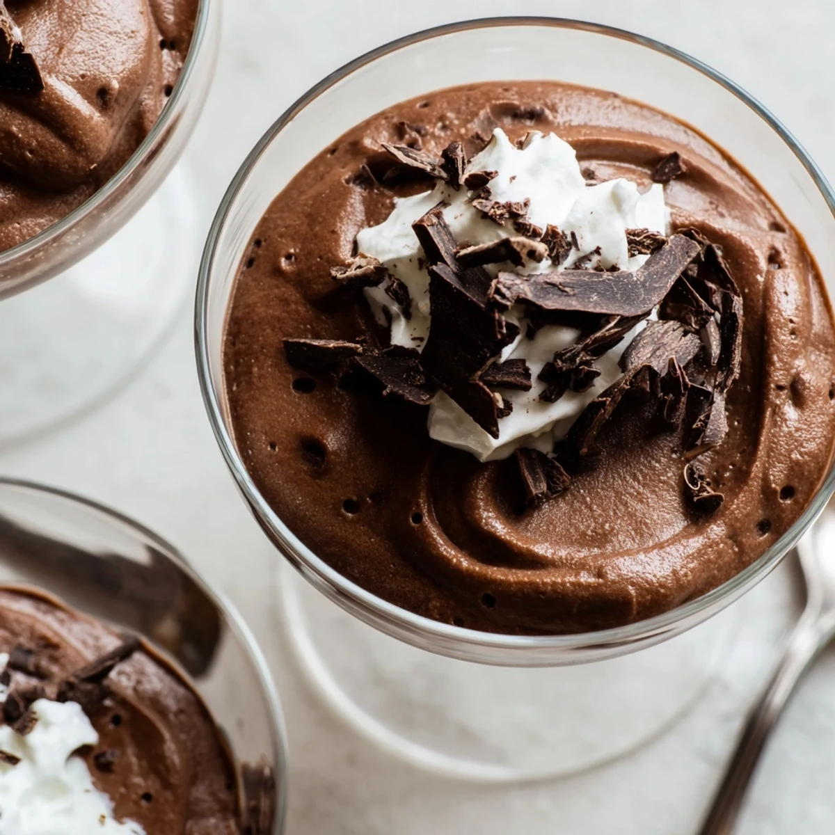 Creamy chocolate mousse chilled to perfection with glossy swirls in glass dessert cups
