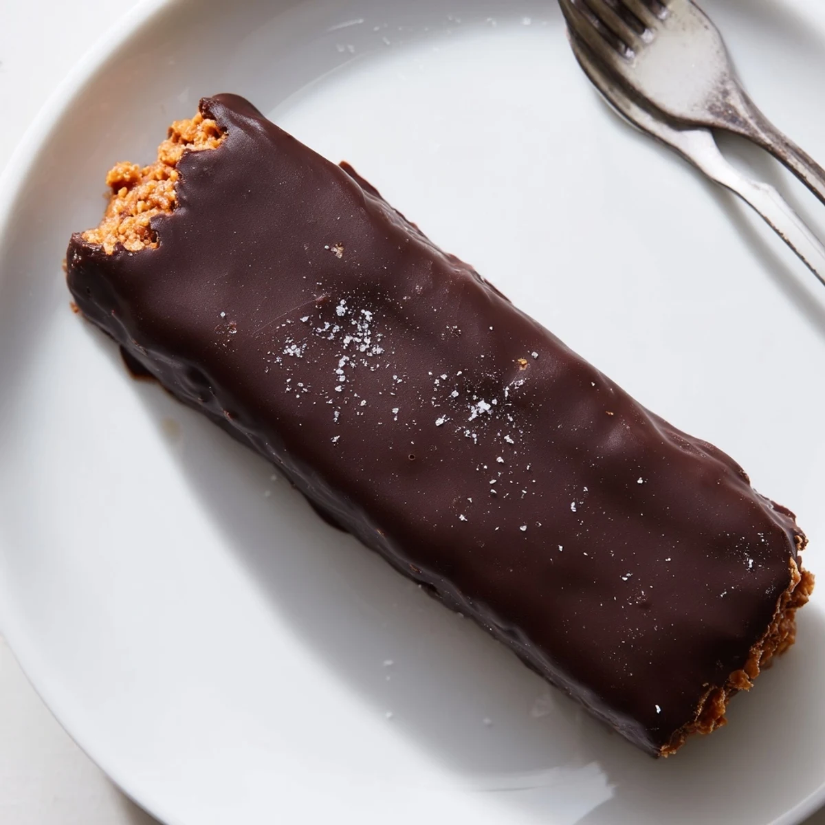 A plate of healthy homemade Butterfingers with a glossy chocolate shell and crispy peanut center