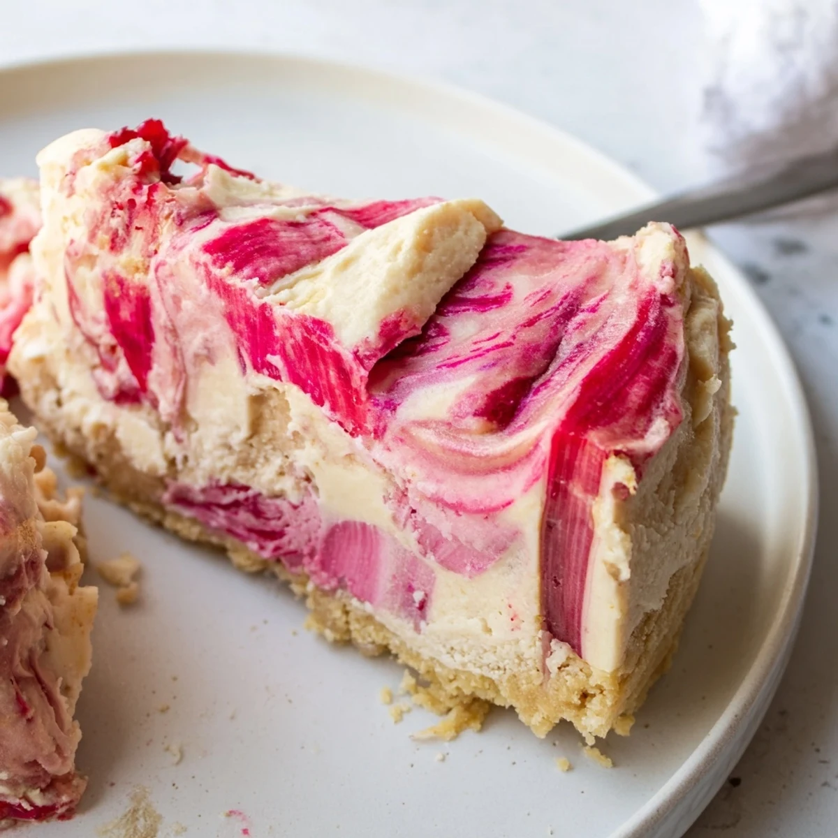 Golden almond flour crust cradles a silky keto rhubarb cheesecake swirled with compote